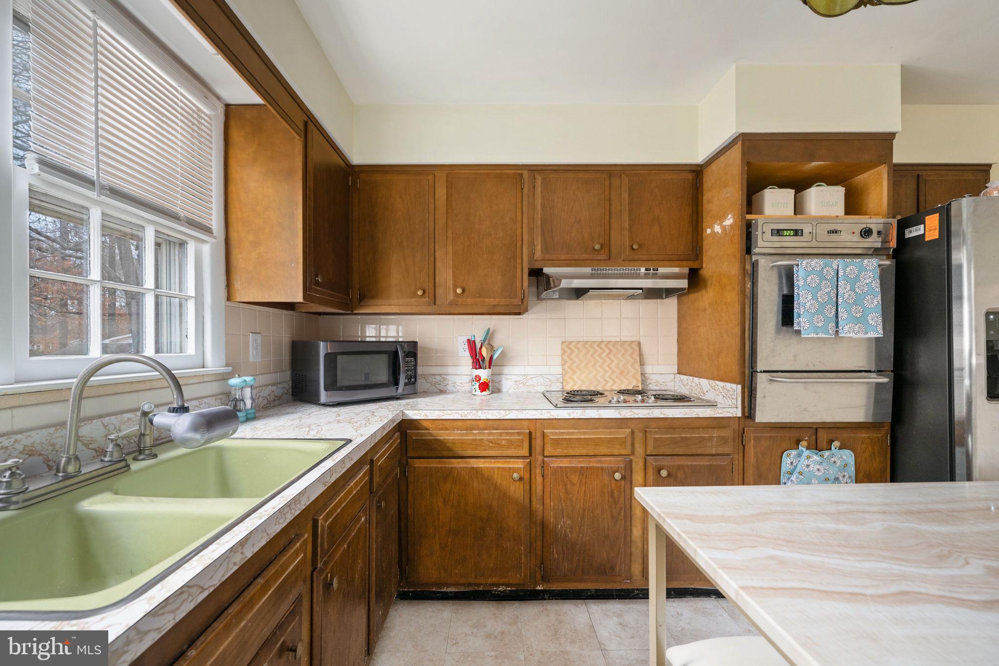 128 11th Street Colonial Beach, VA 22443 - Photo 31 of 80 a kitchen with a sink stove and cabinets