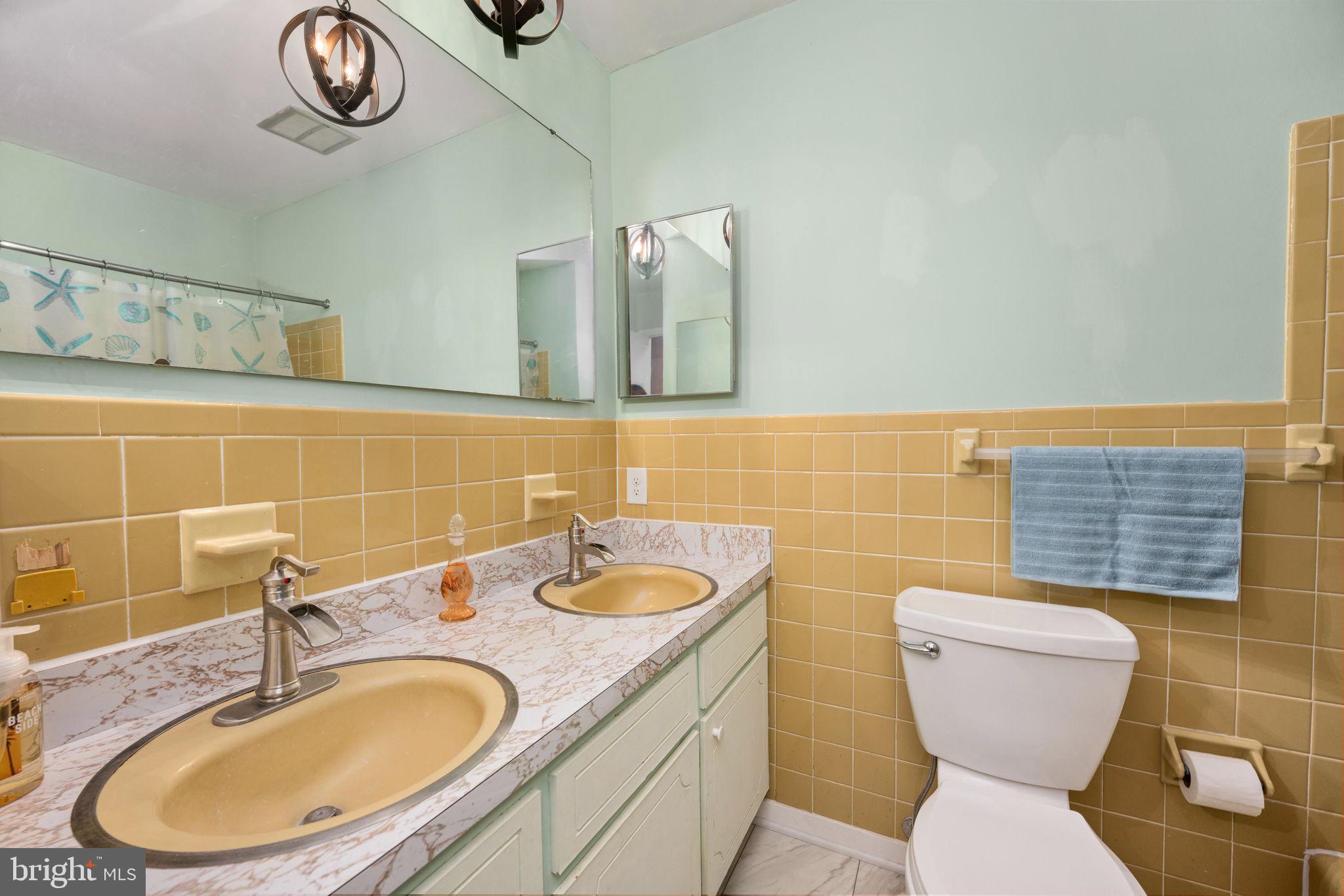 128 11th Street Colonial Beach, VA 22443 - Photo 39 of 80 a bathroom with a toilet a sink and a mirror
