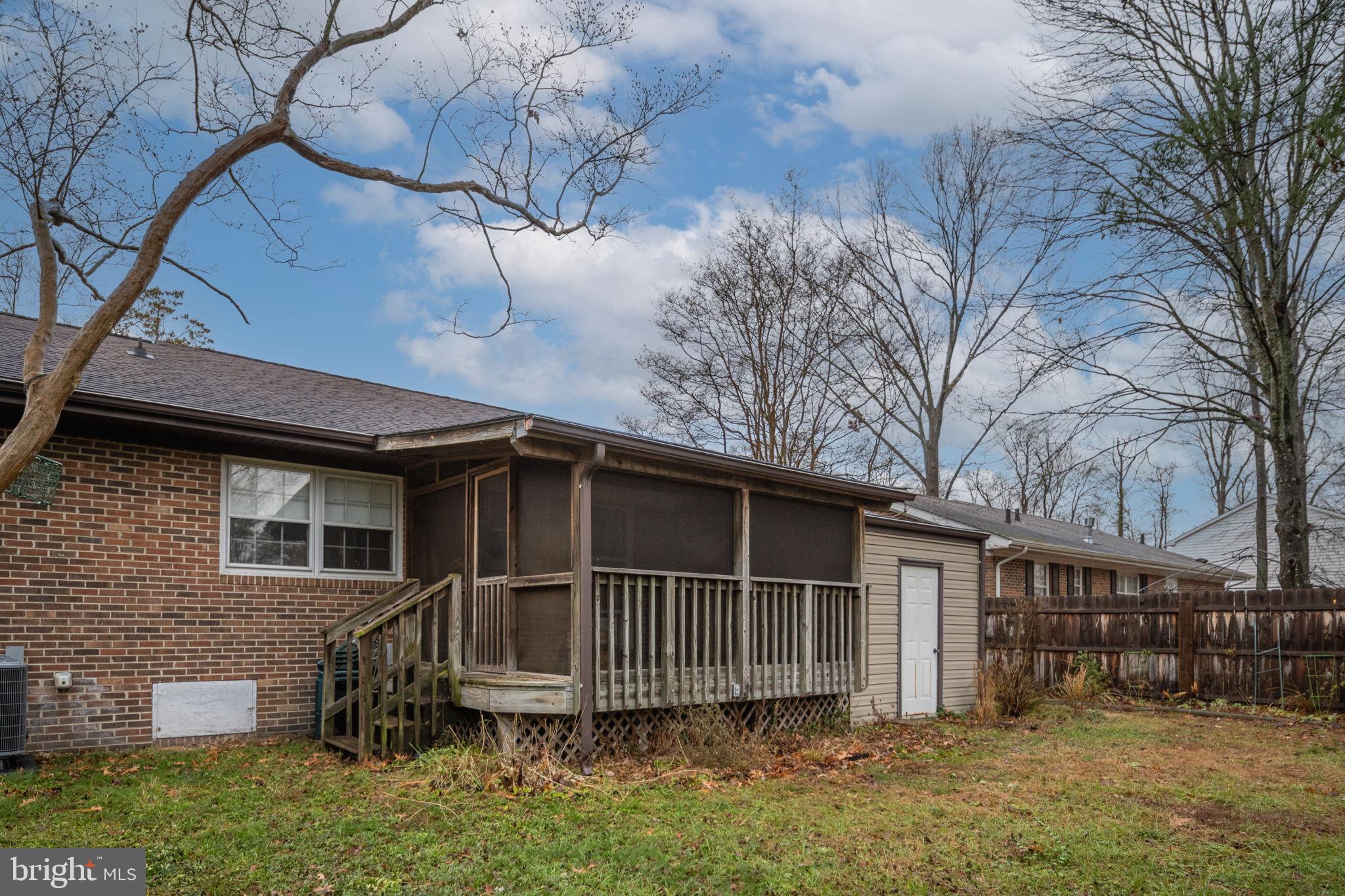 128 11th Street Colonial Beach, VA 22443 - Photo 49 of 58 a backyard of a house with wooden fence and large trees
