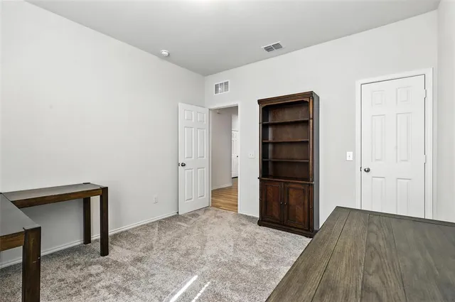 a view of an empty room with a closet and cabinet