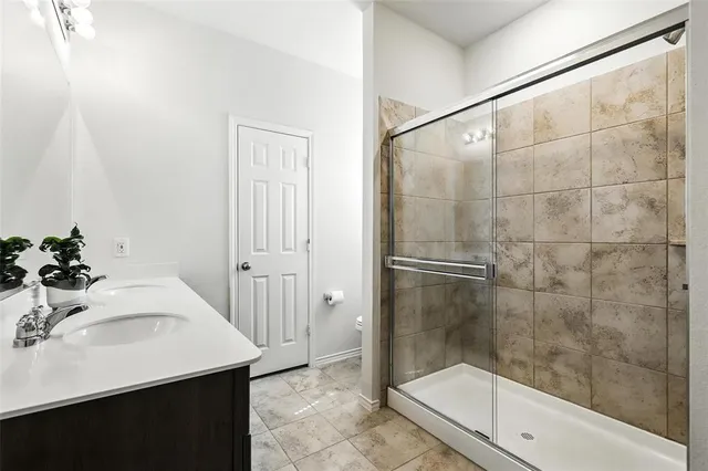 a bathroom with a bathtub shower sink and mirror