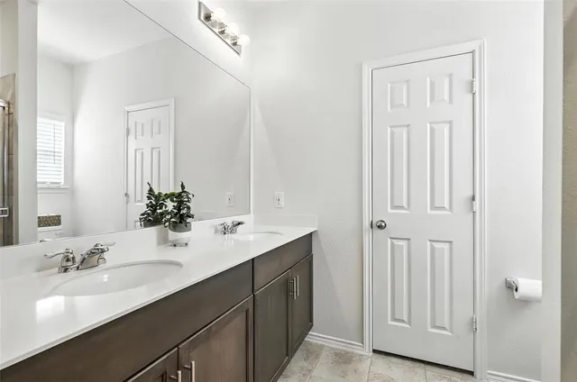 a bathroom with a double vanity sink and a mirror