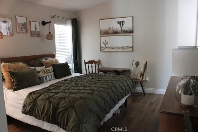 a bedroom with bed and wooden floor