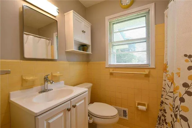 a bathroom with a sink a toilet and a mirror
