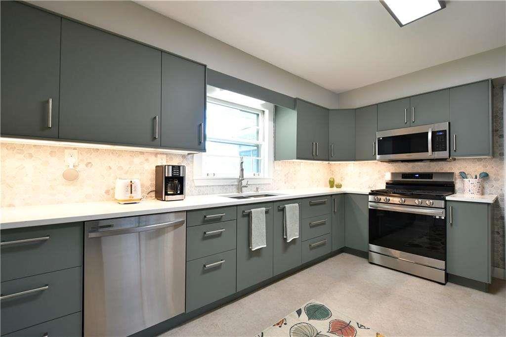 2877 Cartwright Drive Decatur, GA 30033 - Photo 3 of 19 a kitchen with stainless steel appliances granite countertop a sink dishwasher stove and microwave with wooden cabinets