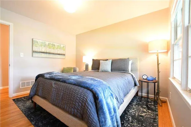 a bedroom with a bed and wooden floor