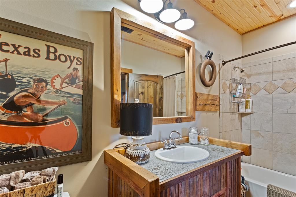 1016 Hells Gate Loop Strawn, TX 76475 - Photo 12 of 31 a bathroom with a granite countertop sink and a mirror