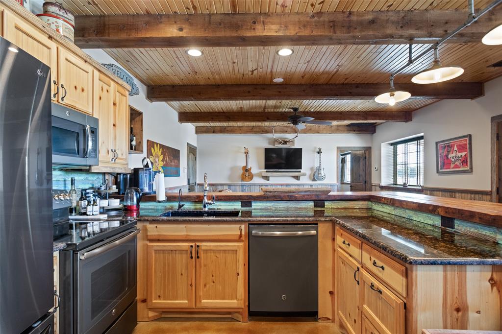 1016 Hells Gate Loop Strawn, TX 76475 - Photo 10 of 31 a kitchen with stainless steel appliances granite countertop a sink and a stove