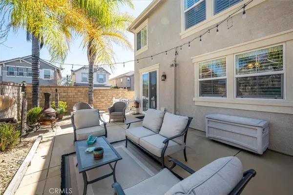 a view of a patio with couches table and chairs and potted plants