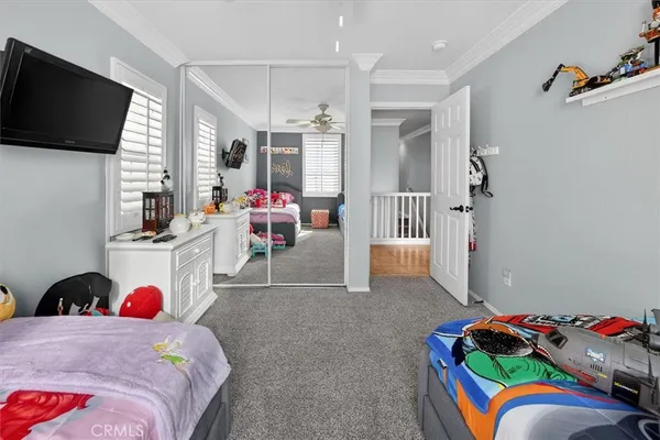 a spacious bedroom with a bed a couch and a chandelier