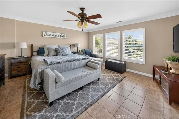 a bedroom with a bed couch tv and a window