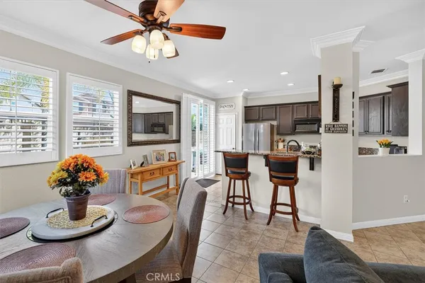 a kitchen with stainless steel appliances granite countertop a table chairs sink refrigerator and microwave