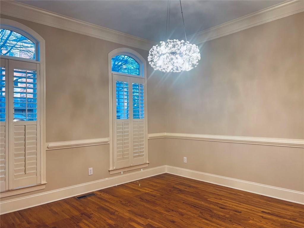 144 West Ridge Way Roswell, GA 30076 - Photo 7 of 30 an empty room with wooden floor chandelier and windows