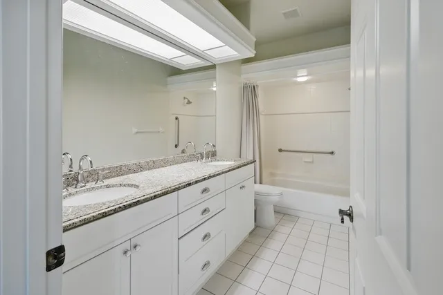 a bathroom with a granite countertop sink a toilet and shower
