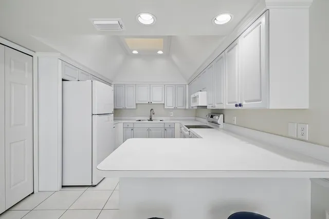 a view of a kitchen with white cabinets
