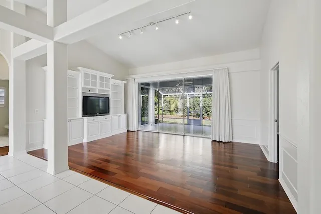 a view of empty room with wooden floor and fireplace