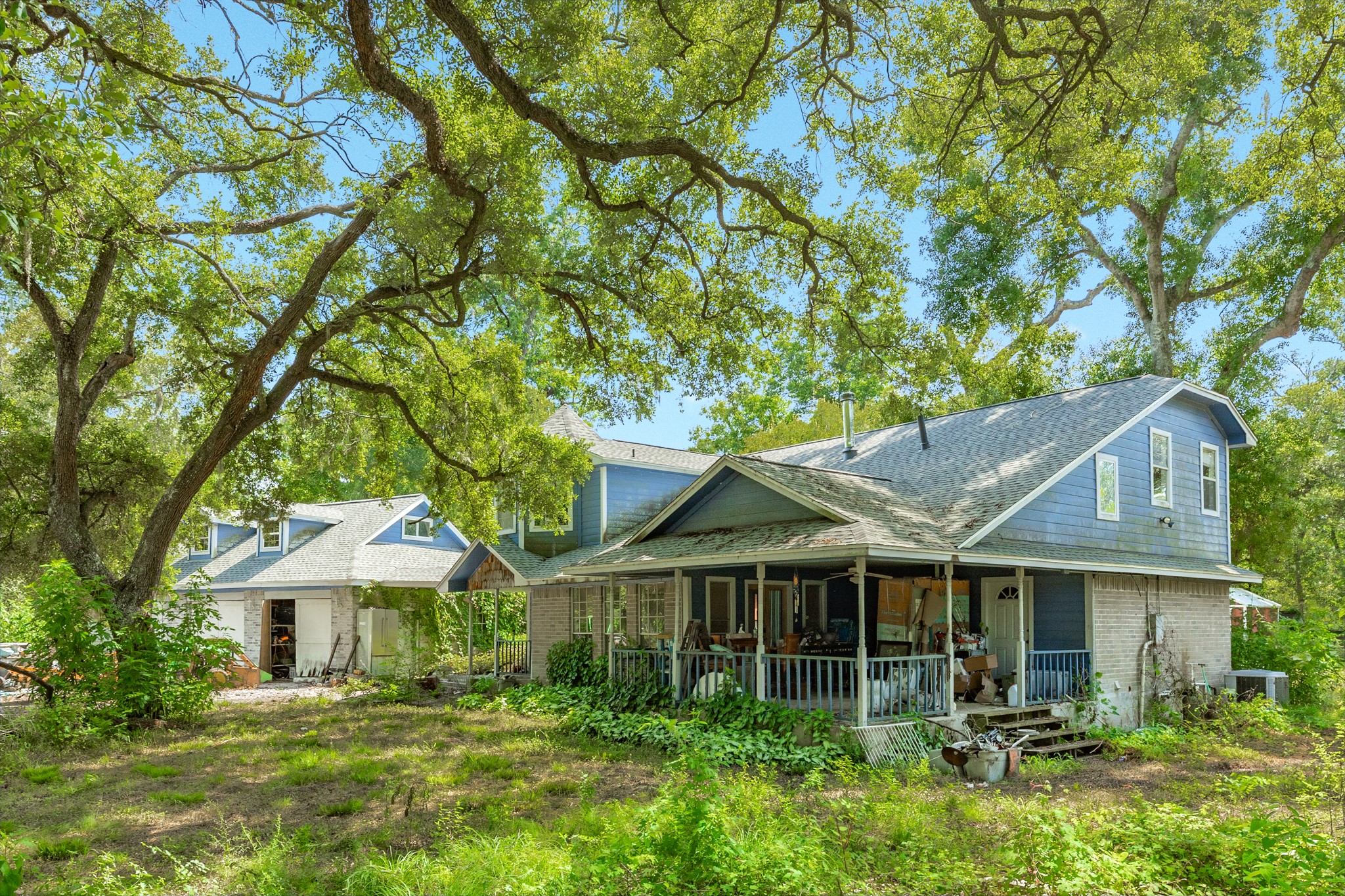 16406 Lochness Street, Unit C528B Rosharon, TX 77583 - Photo 5 of 21 The front elevation showcases the home's inviting wraparound porch, timeless architecture, and picturesque setting beneath a canopy of mature oak trees.