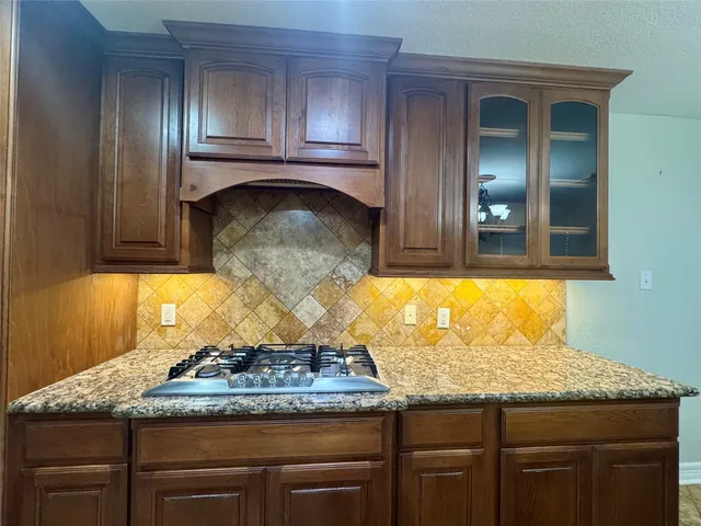 a bathroom with a granite countertop sink and a wooden floor