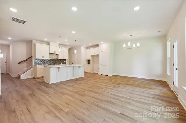 a view of large kitchen with kitchen island wooden cabinets and stainless steel appliances