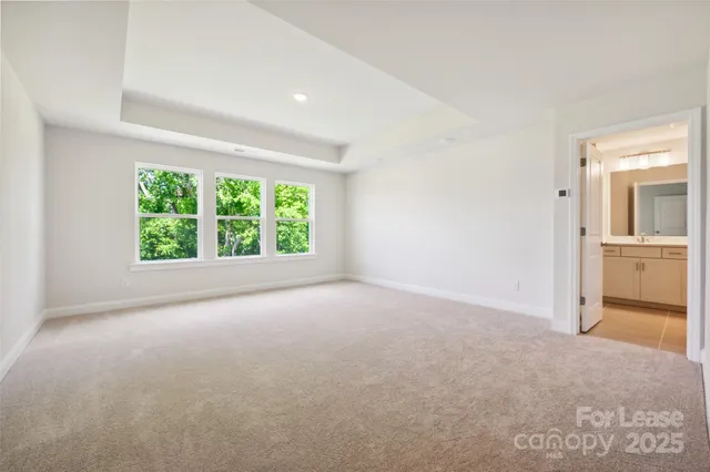 an empty room with a open kitchen and a window
