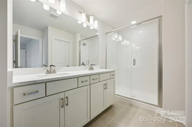 a bathroom with double sink and a mirror
