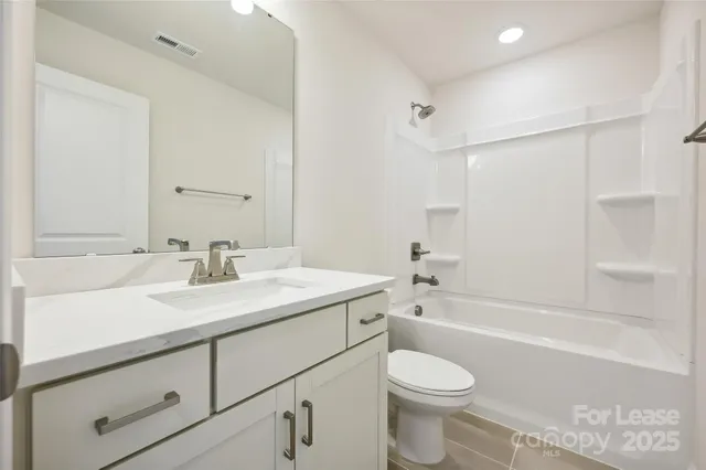 a bathroom with a sink toilet vanity tub and shower