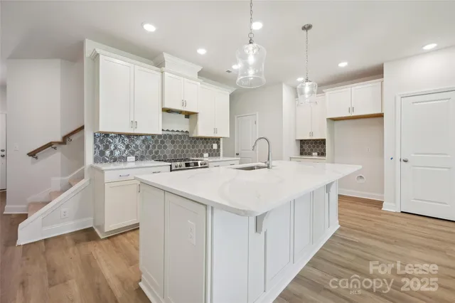 a kitchen with kitchen island white cabinets and stainless steel appliances