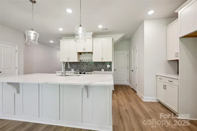a large kitchen with a sink stainless steel appliances and cabinets