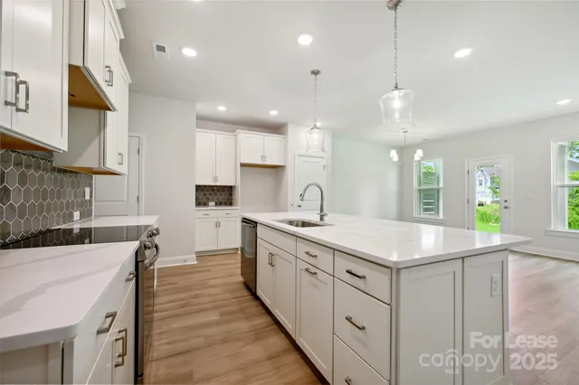 a kitchen with kitchen island a sink stainless steel appliances and cabinets