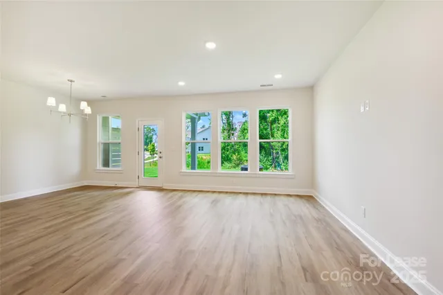 an empty room with wooden floor and a window