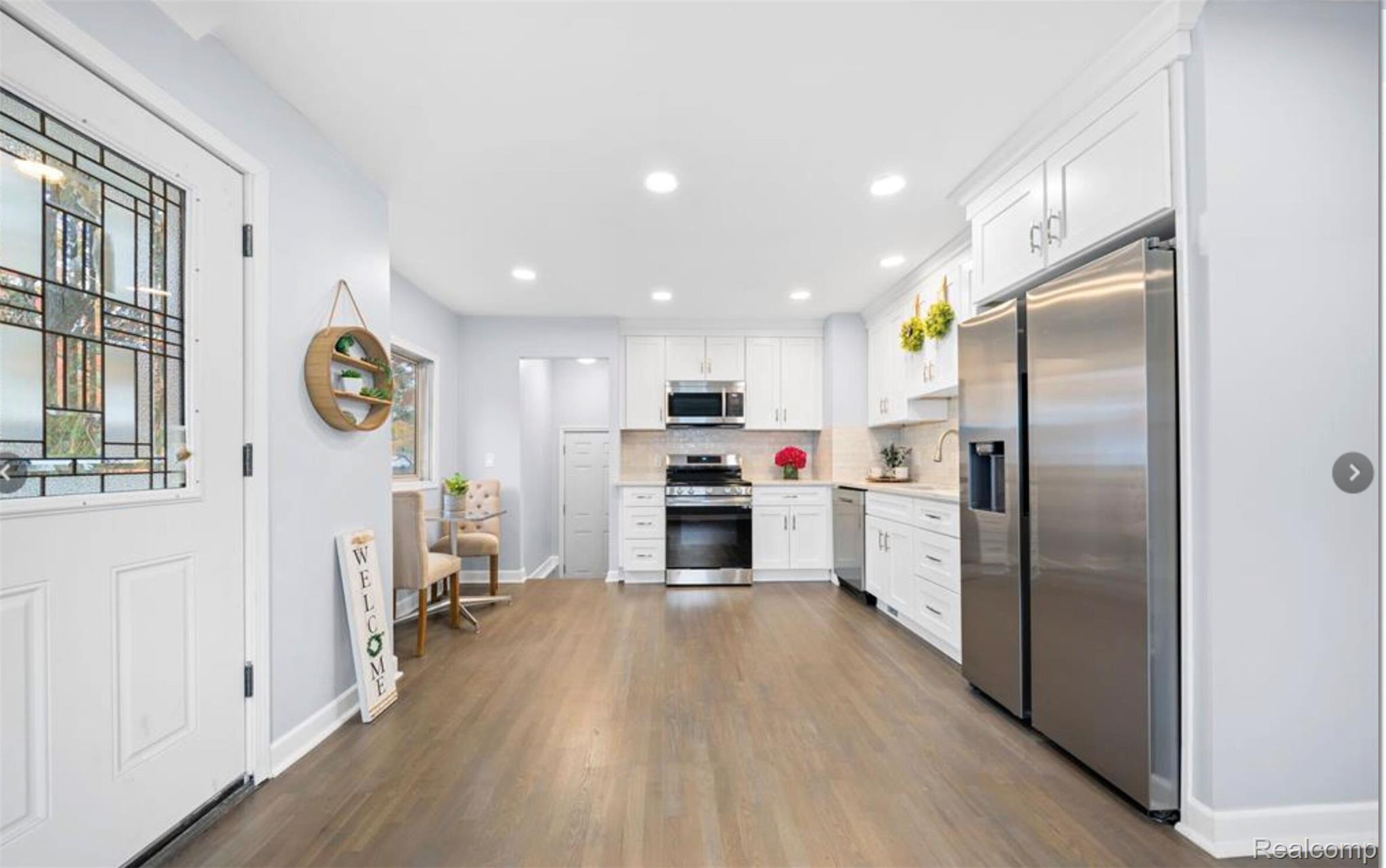 4214 Berkshire Road Royal Oak, MI 48073 - Photo 10 of 27 Open-concept kitchen featuring wood-finish flooring, white cabinetry, stainless steel appliances, and recessed lighting
