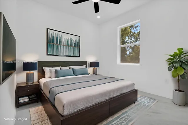 a bedroom with bed and a potted plant