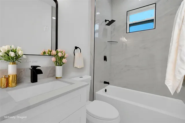 a bathroom with a granite countertop sink a toilet and bathtub