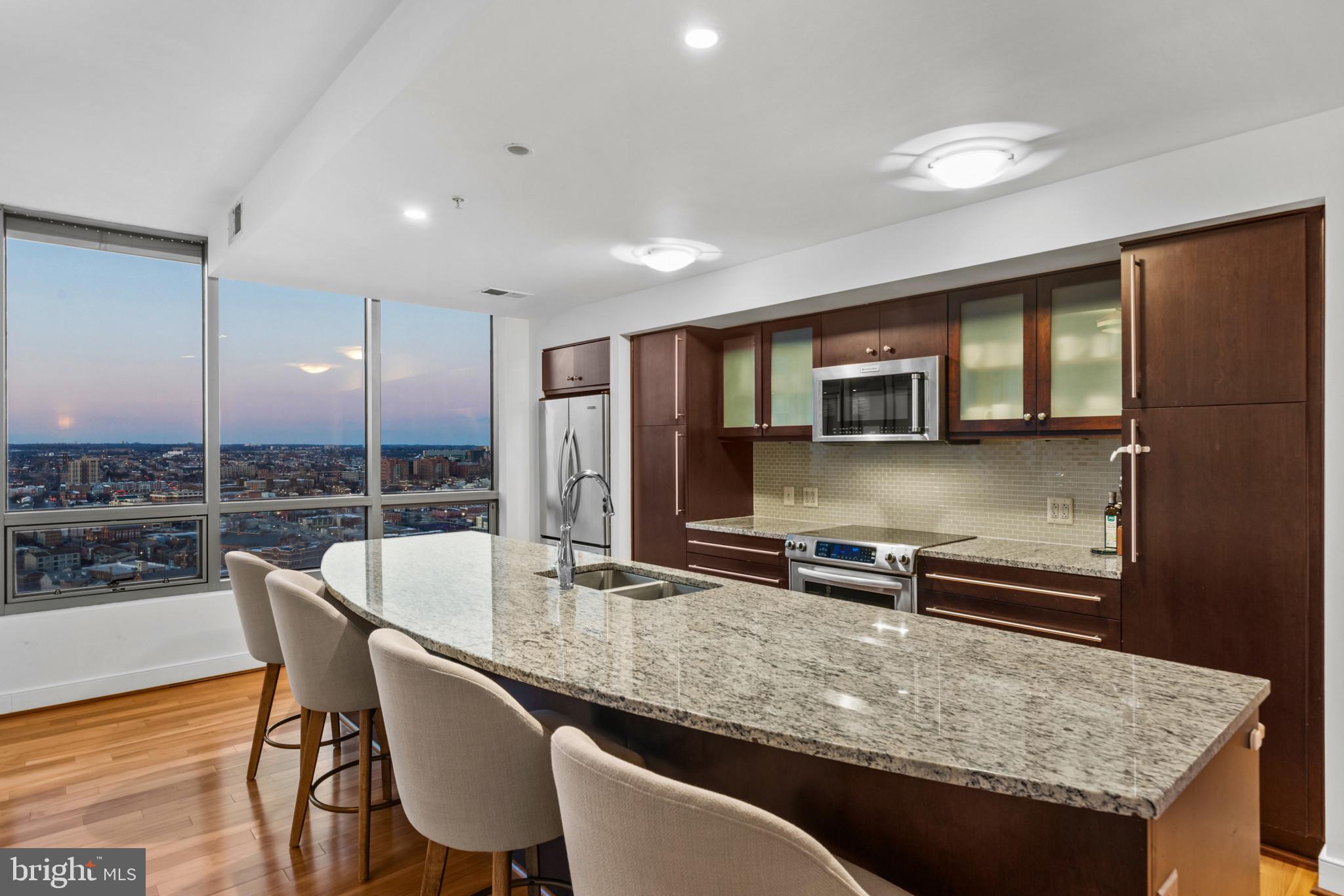 675 President Street, Unit 2706 Baltimore, MD 21202 - Photo 15 of 49 a dining hall with stainless steel appliances granite countertop a sink table and chairs