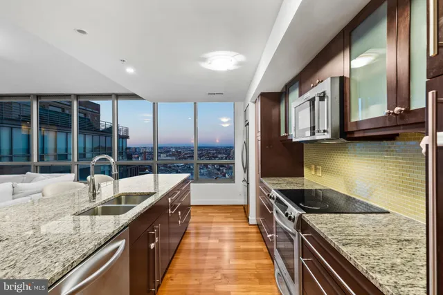 a kitchen with stainless steel appliances granite countertop a sink and a stove