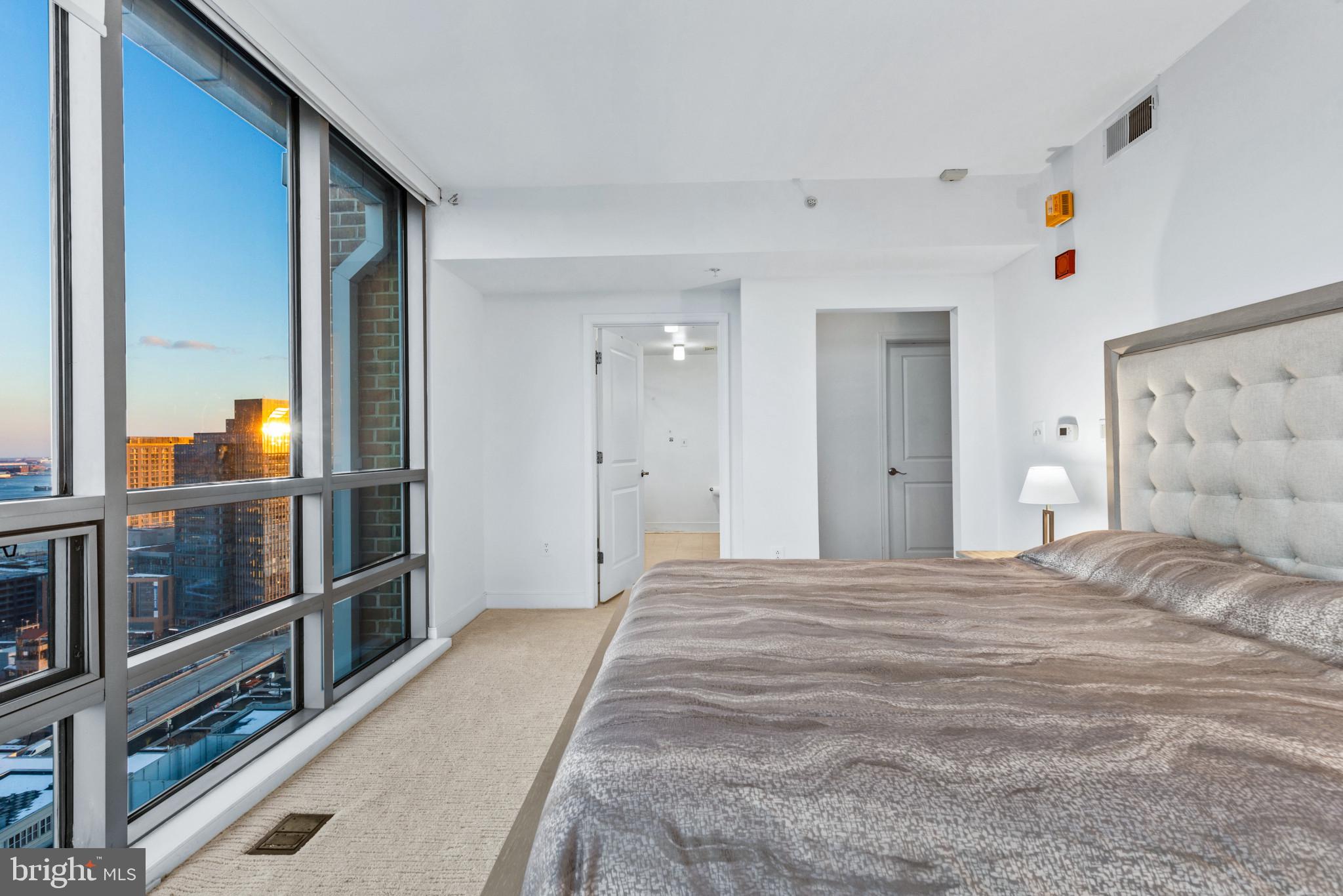 675 President Street, Unit 2706 Baltimore, MD 21202 - Photo 22 of 49 a view of a bedroom with wooden floor and bathroom
