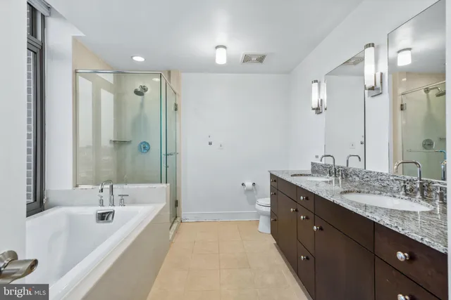 a spacious bathroom with a tub sink shower and mirror
