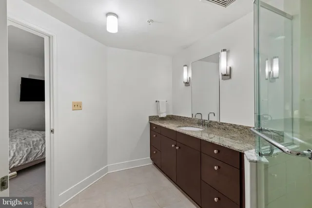 a bathroom with a granite countertop sink and a mirror