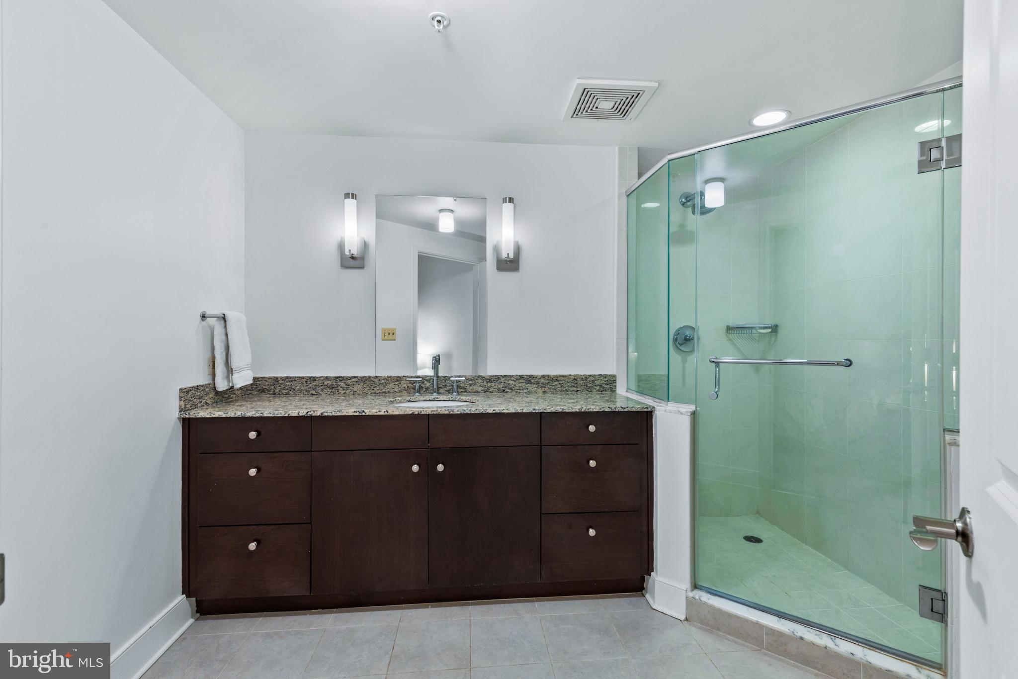 675 President Street, Unit 2706 Baltimore, MD 21202 - Photo 36 of 49 a bathroom with a granite countertop sink mirror and shower