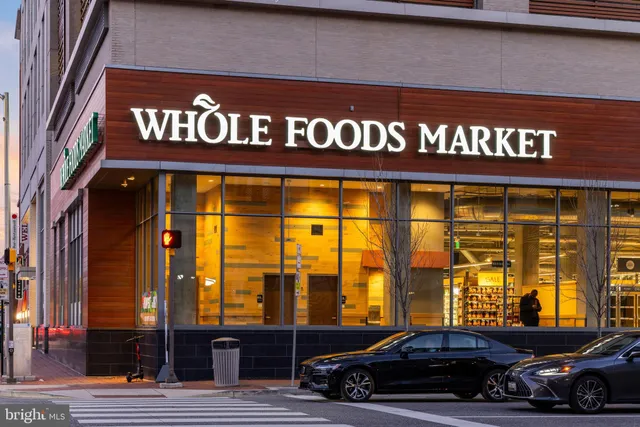 a city street lined with tall buildings and cars parked on the street