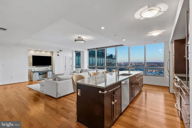 a kitchen with kitchen island granite countertop a sink and a stove top oven