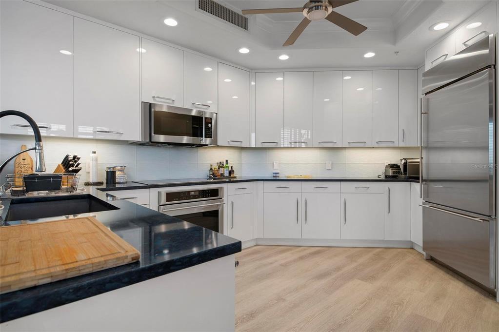 9122 Midnight Pass Road, Unit 34 Sarasota, FL 34242 - Photo 15 of 61 a kitchen with kitchen island granite countertop stainless steel appliances refrigerator sink and microwave