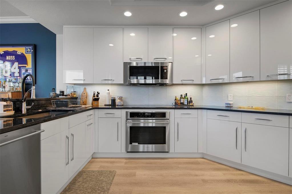 9122 Midnight Pass Road, Unit 34 Sarasota, FL 34242 - Photo 16 of 61 a kitchen with stainless steel appliances granite countertop a stove a sink and a white cabinets