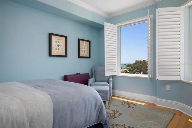 a spacious bedroom with a large bed and a flat tv screen on dresser