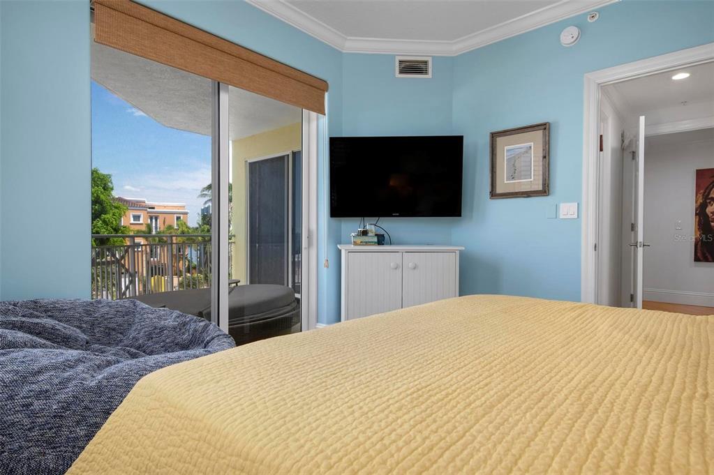 9122 Midnight Pass Road, Unit 34 Sarasota, FL 34242 - Photo 24 of 61 a bedroom with a bed and a flat screen tv