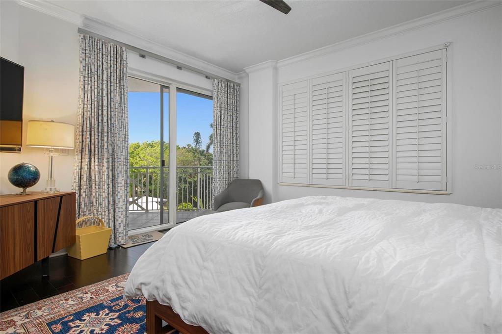 9122 Midnight Pass Road, Unit 34 Sarasota, FL 34242 - Photo 27 of 61 a bedroom with a bed and glass door