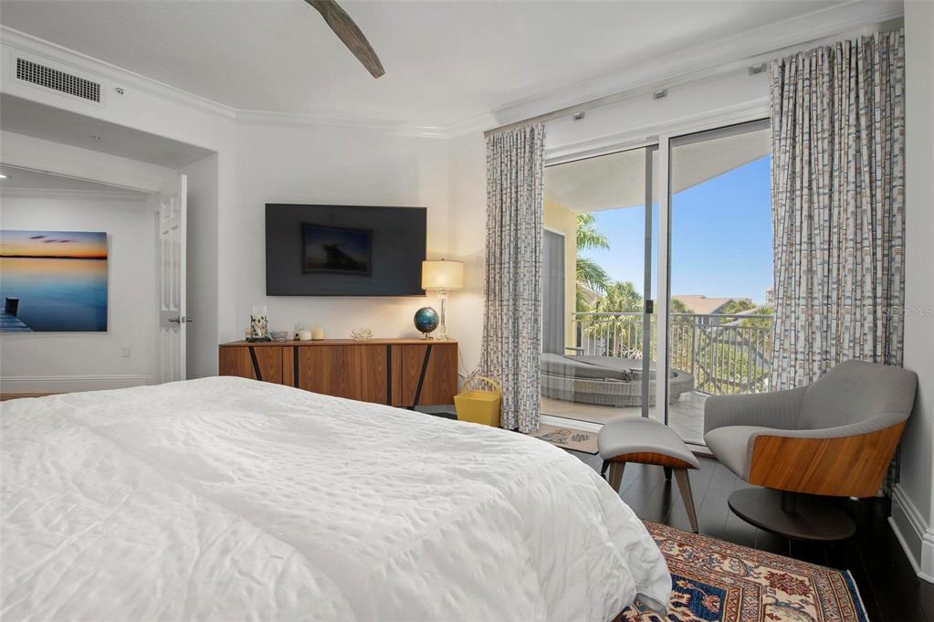 9122 Midnight Pass Road, Unit 34 Sarasota, FL 34242 - Photo 28 of 61 a bedroom with a bed and a flat screen tv