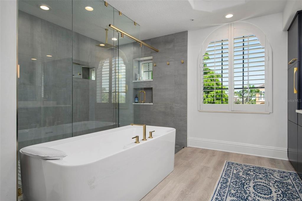 9122 Midnight Pass Road, Unit 34 Sarasota, FL 34242 - Photo 32 of 61 a white bath tub sitting in a bathroom next to a window