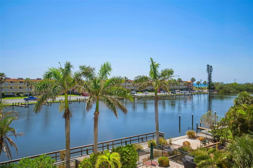 9122 Midnight Pass Road, Unit 34 Sarasota, FL 34242 - Photo 36 of 61 a view of a lake with a table and chairs