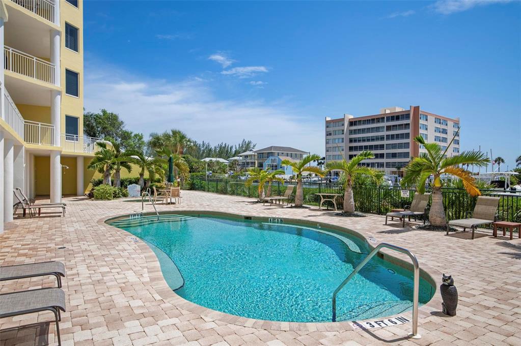 9122 Midnight Pass Road, Unit 34 Sarasota, FL 34242 - Photo 45 of 61 a swimming pool with outdoor seating and city view
